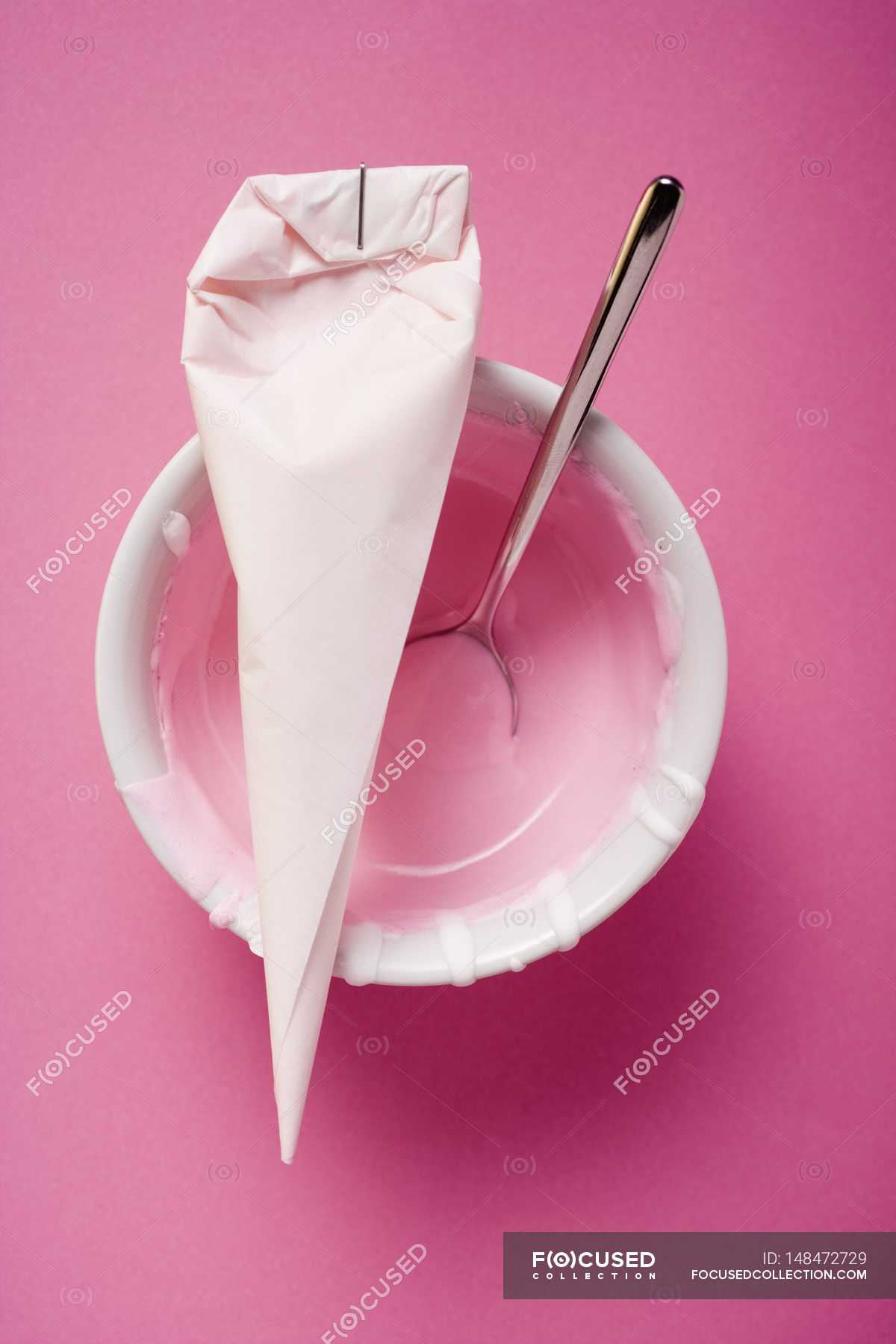 top-view-of-piping-bag-with-pink-icing-and-spoon-food-color-image