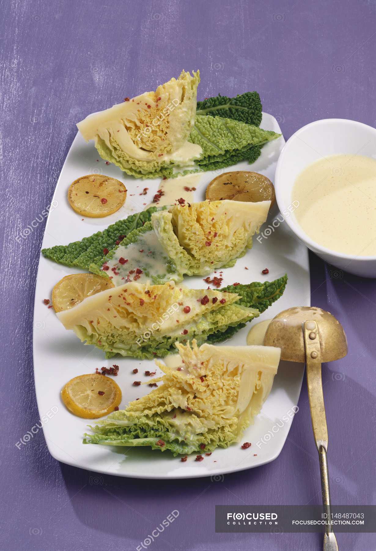 Savoy cabbage with lemon sauce and red pepper on white plate over ...