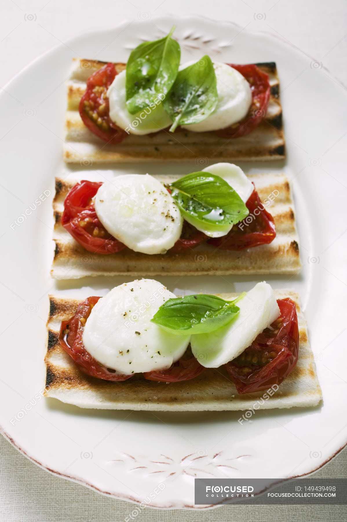 Tomato and mozzarella toasts with basil — cooked, vegetarian Stock