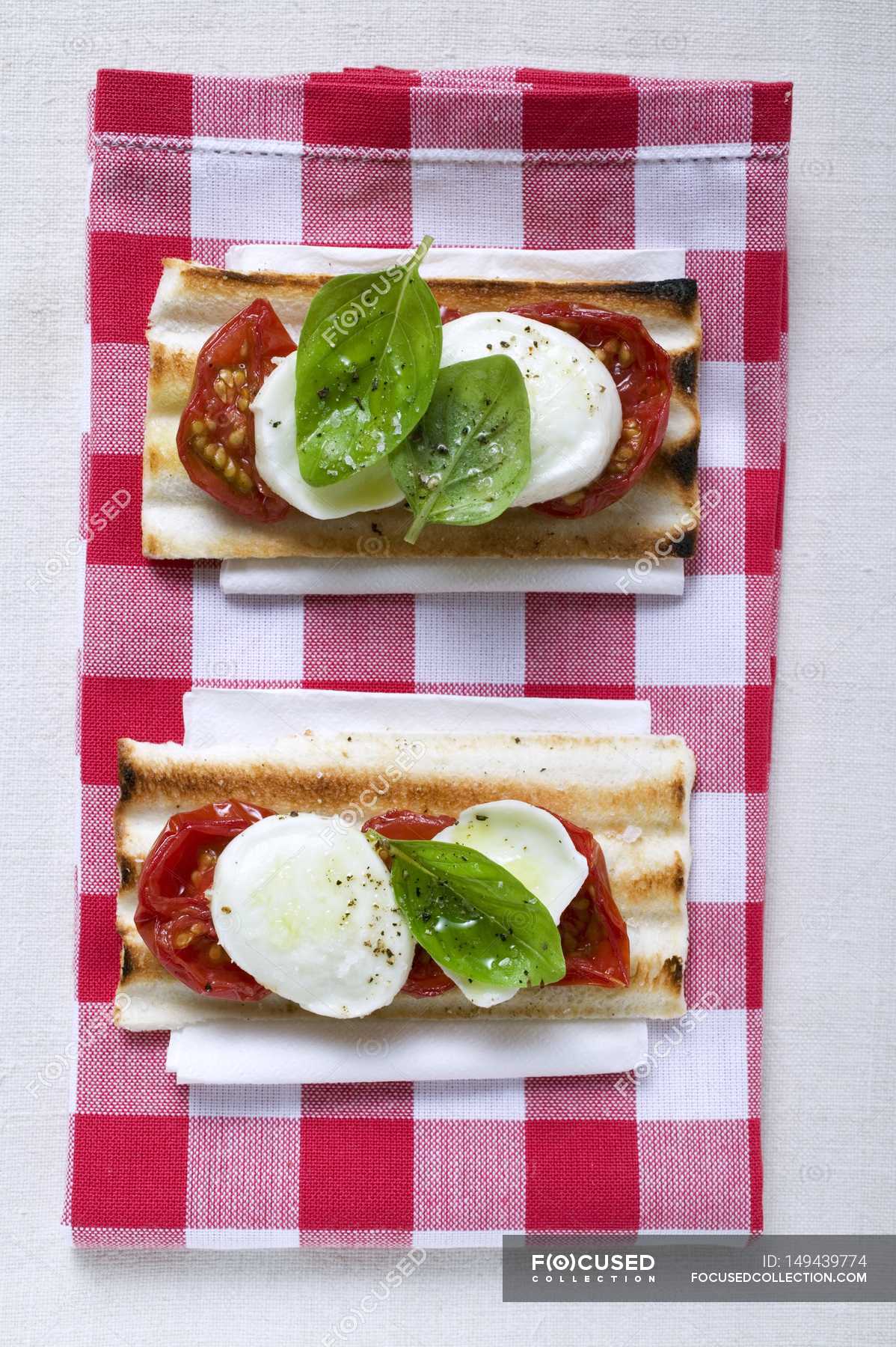 Tomato and mozzarella toasts with basil — appetizing, napkin Stock