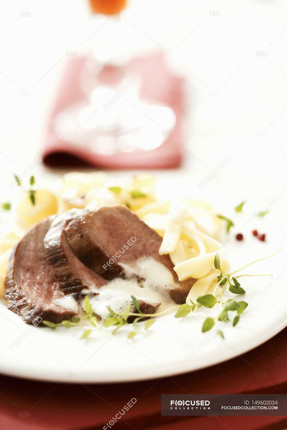 Fried duck breast with ribbon pasta — indoors, white - Stock Photo