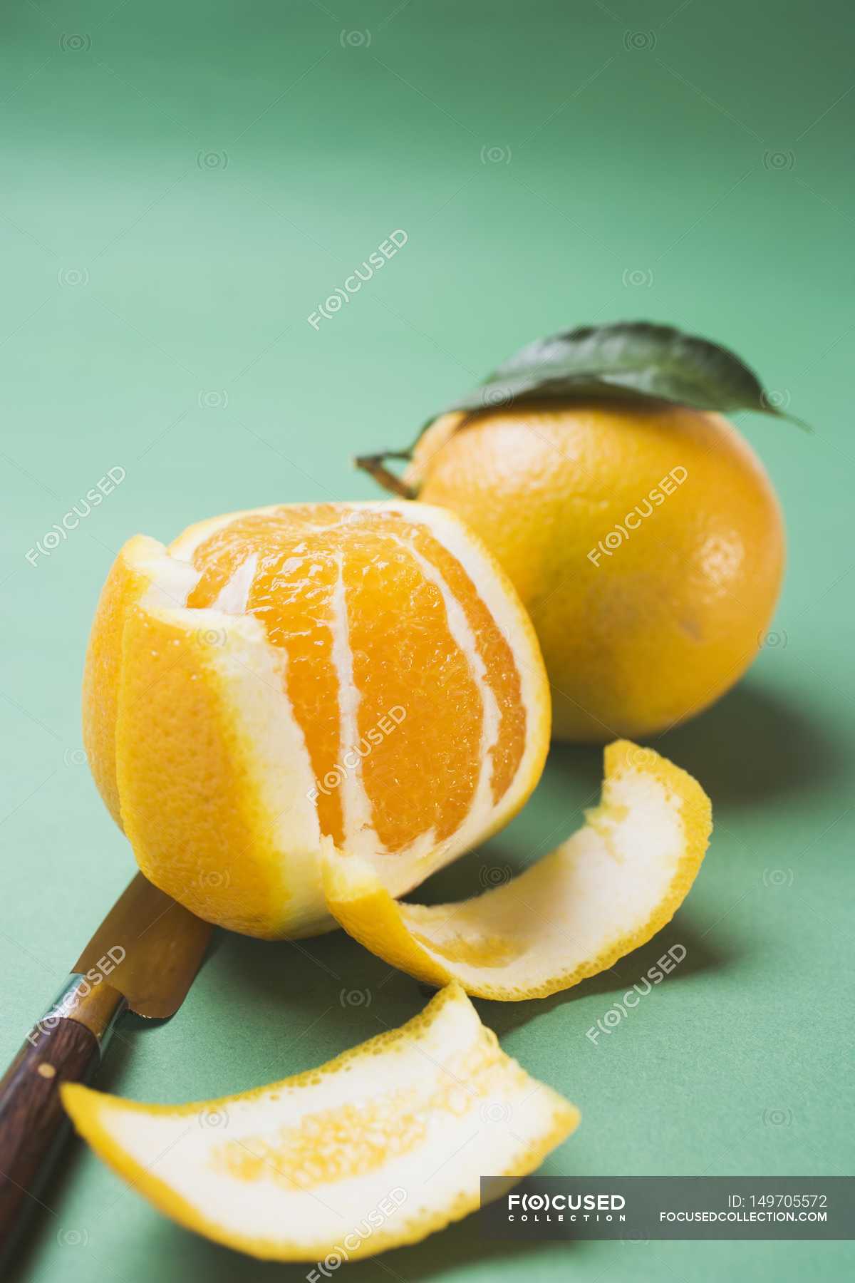 Peeled and unpeeled fresh oranges — vegan, raw food Stock Photo