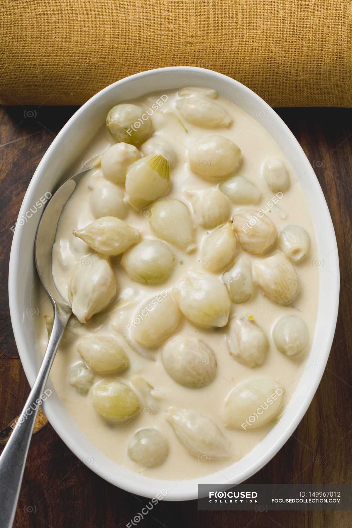 Pearl onions in cream sauce in dish with spoon — lifestyle, product