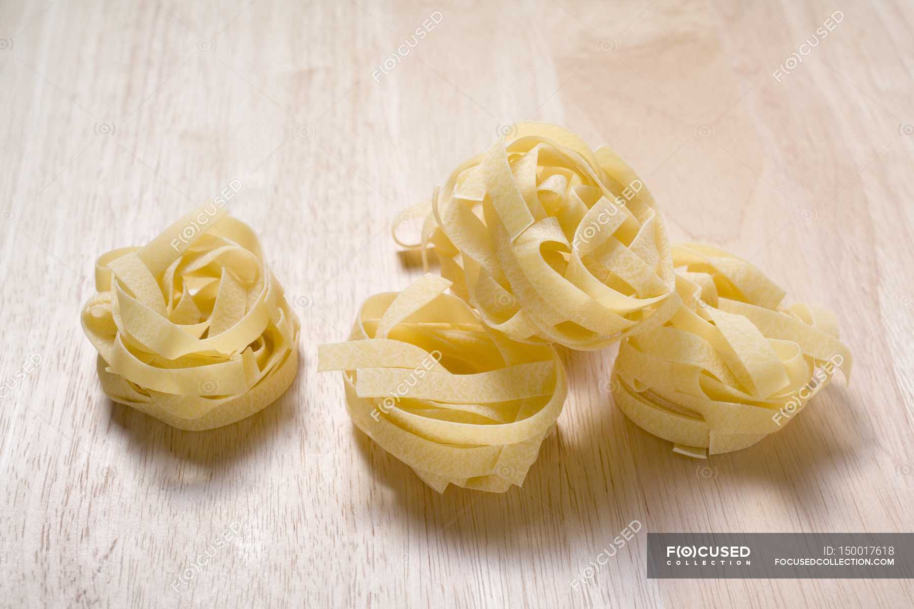 Dried tagliatelle pasta nests — wooden, healthy Stock Photo 150017618