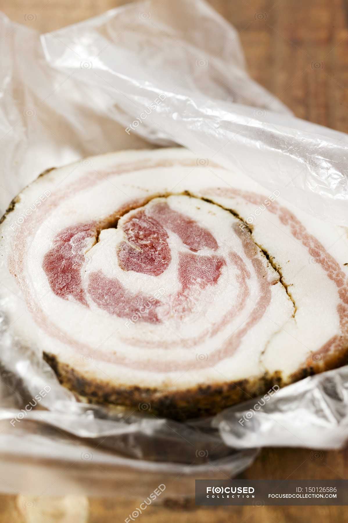 Closeup view of a slice of Pancetta on plastic food wrap — nutrition