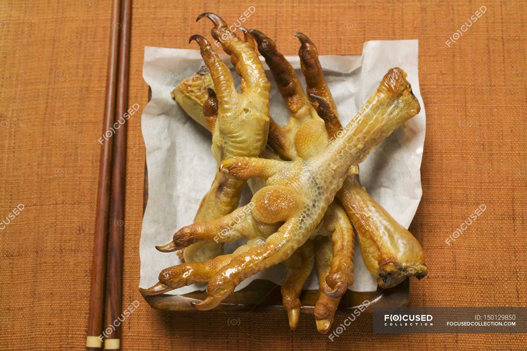 Deep-fried chicken feet on paper — recipe, poultry - Stock Photo