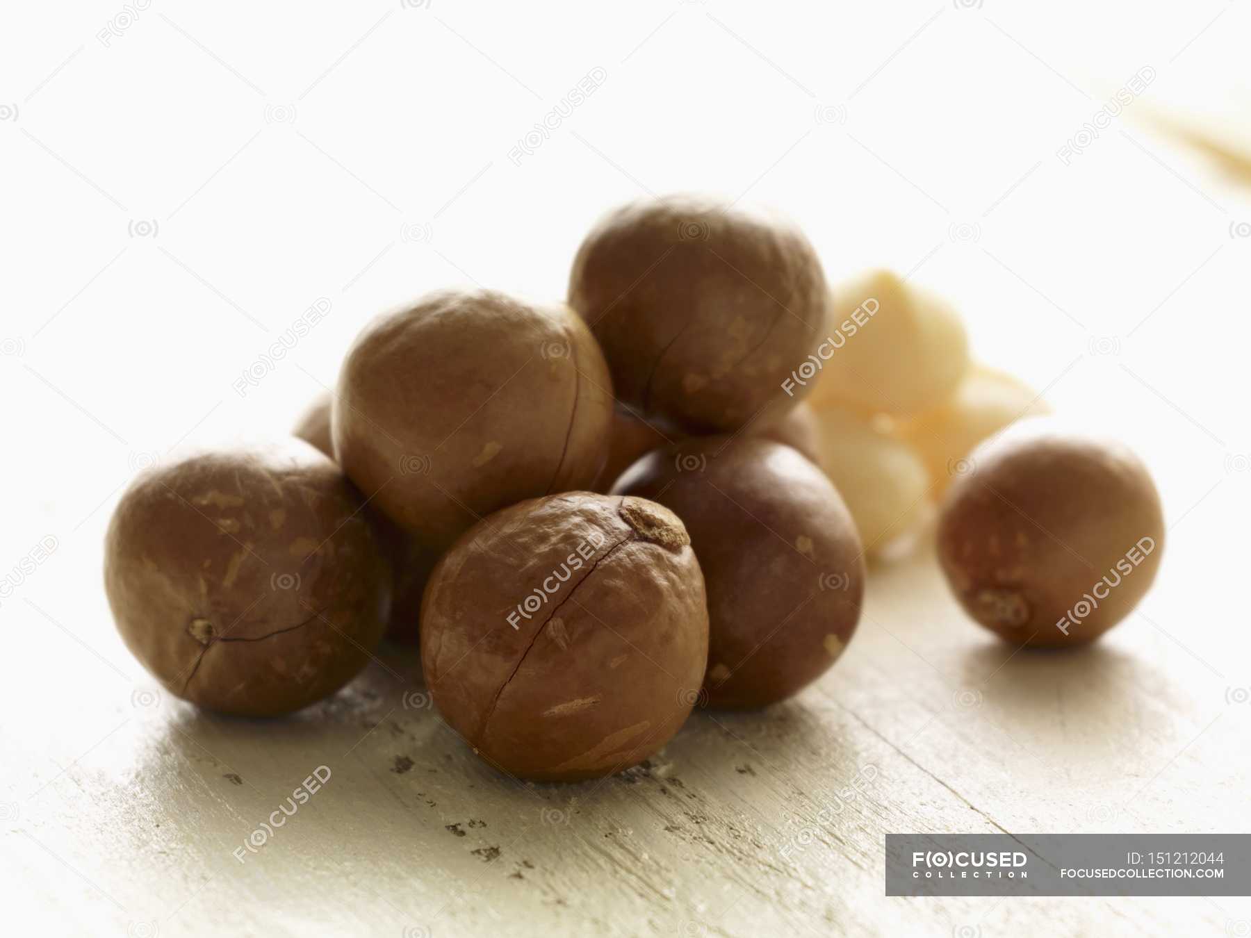 Macadamia nuts in shells — raw, delicious Stock Photo 151212044