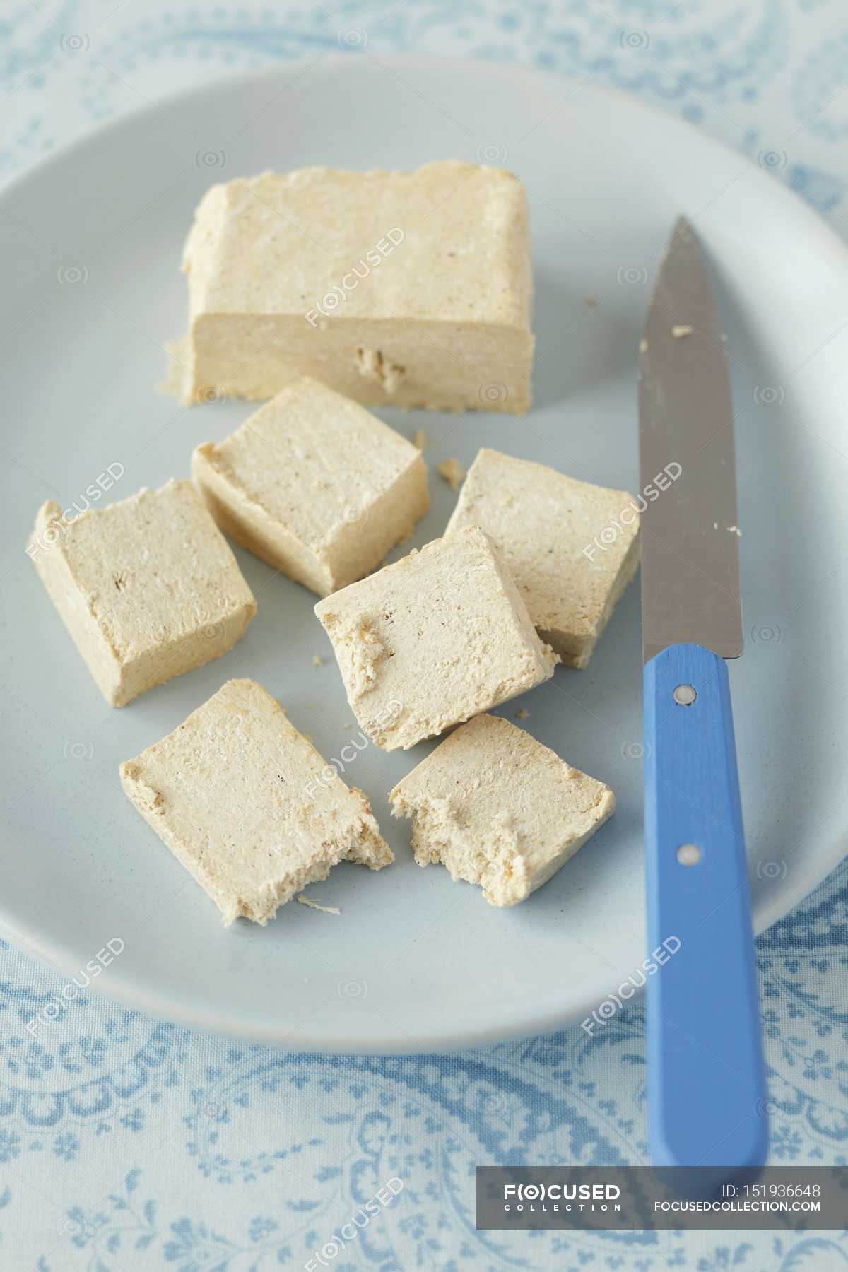 Closeup view of sliced vanilla halva with knife on plate — sweet