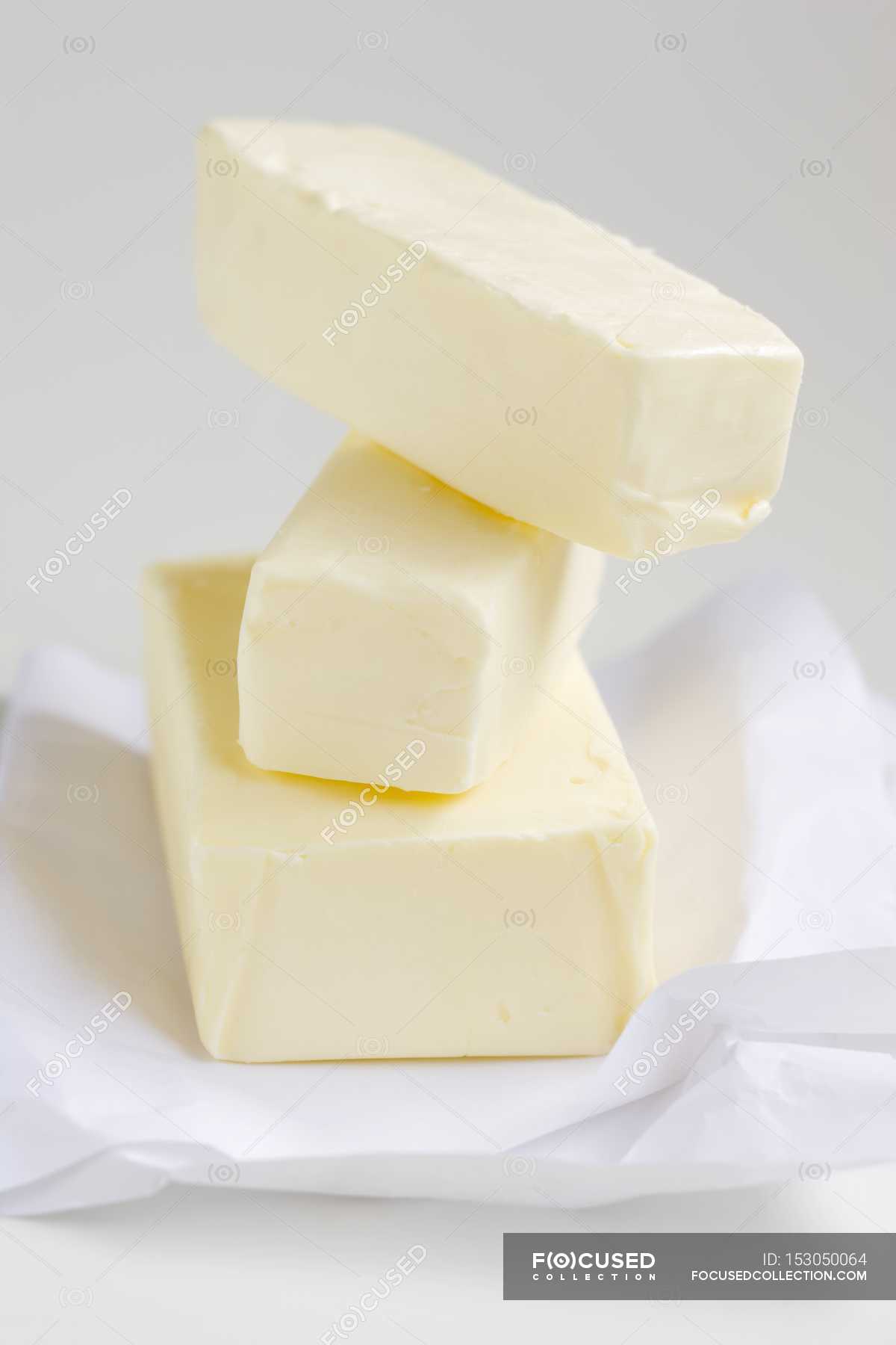Closeup view of stacked blocks of butter on paper — flavour, details