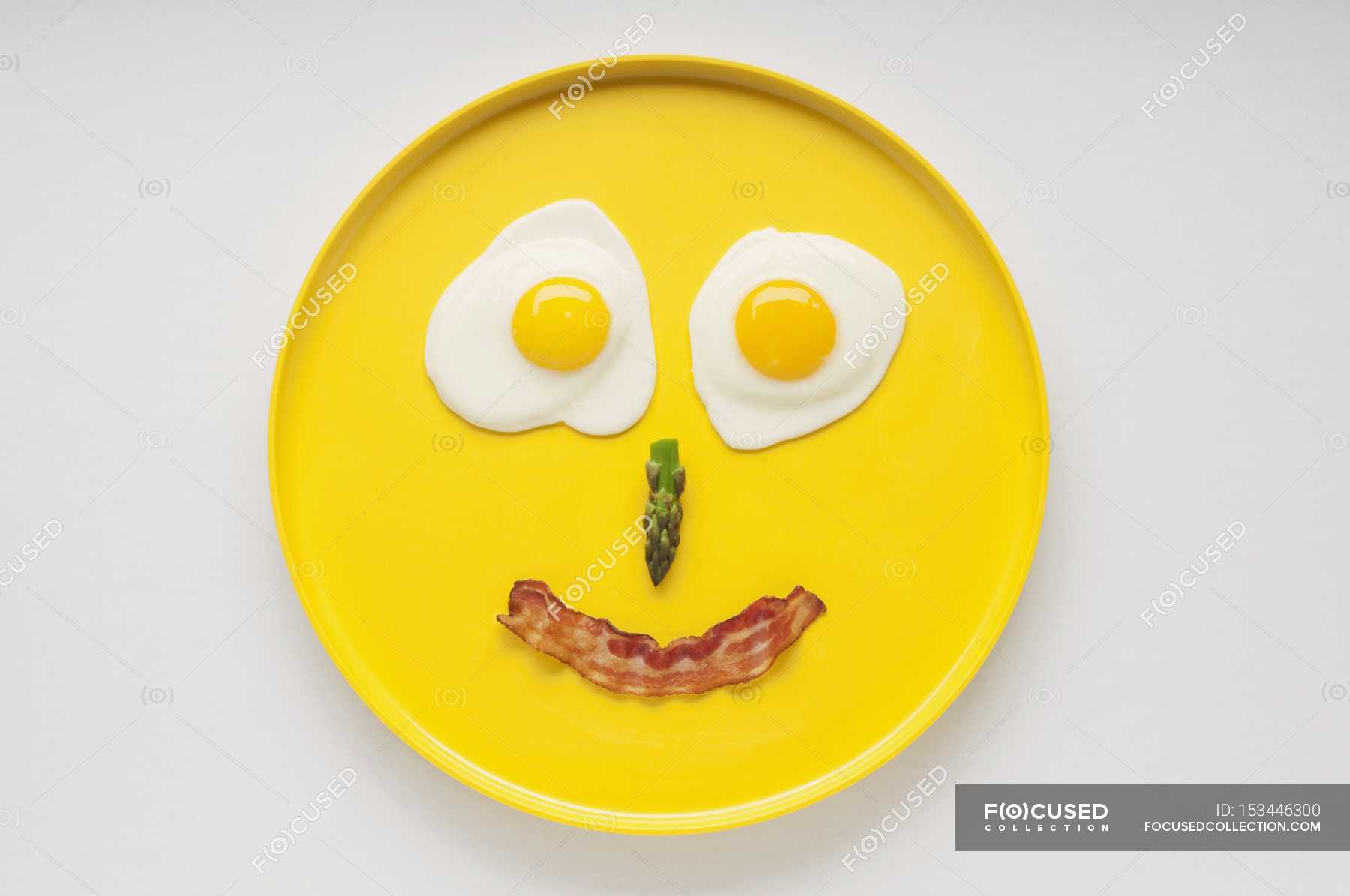 smiley-face-on-a-yellow-plate-made-from-two-fried-eggs-asparagus-and-a