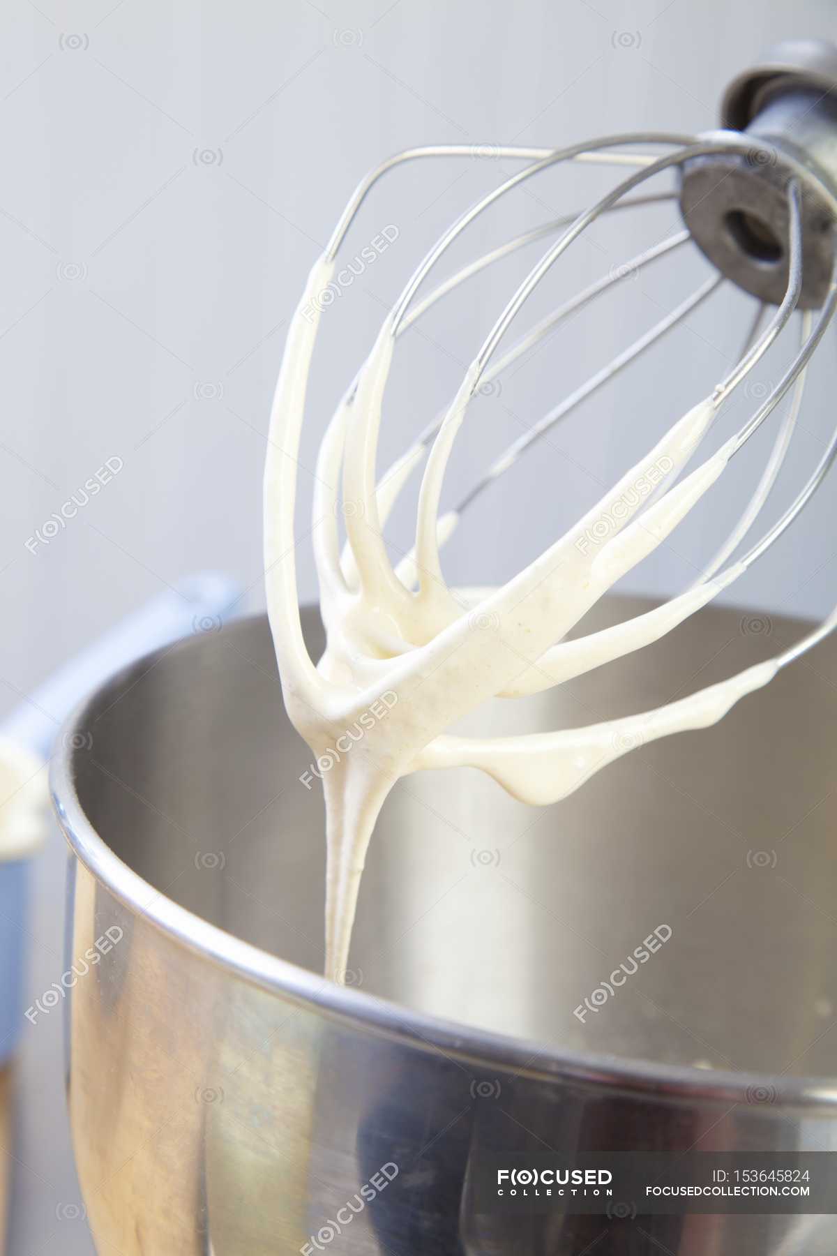 Closeup view of an egg whisk on a food processor with remnants of