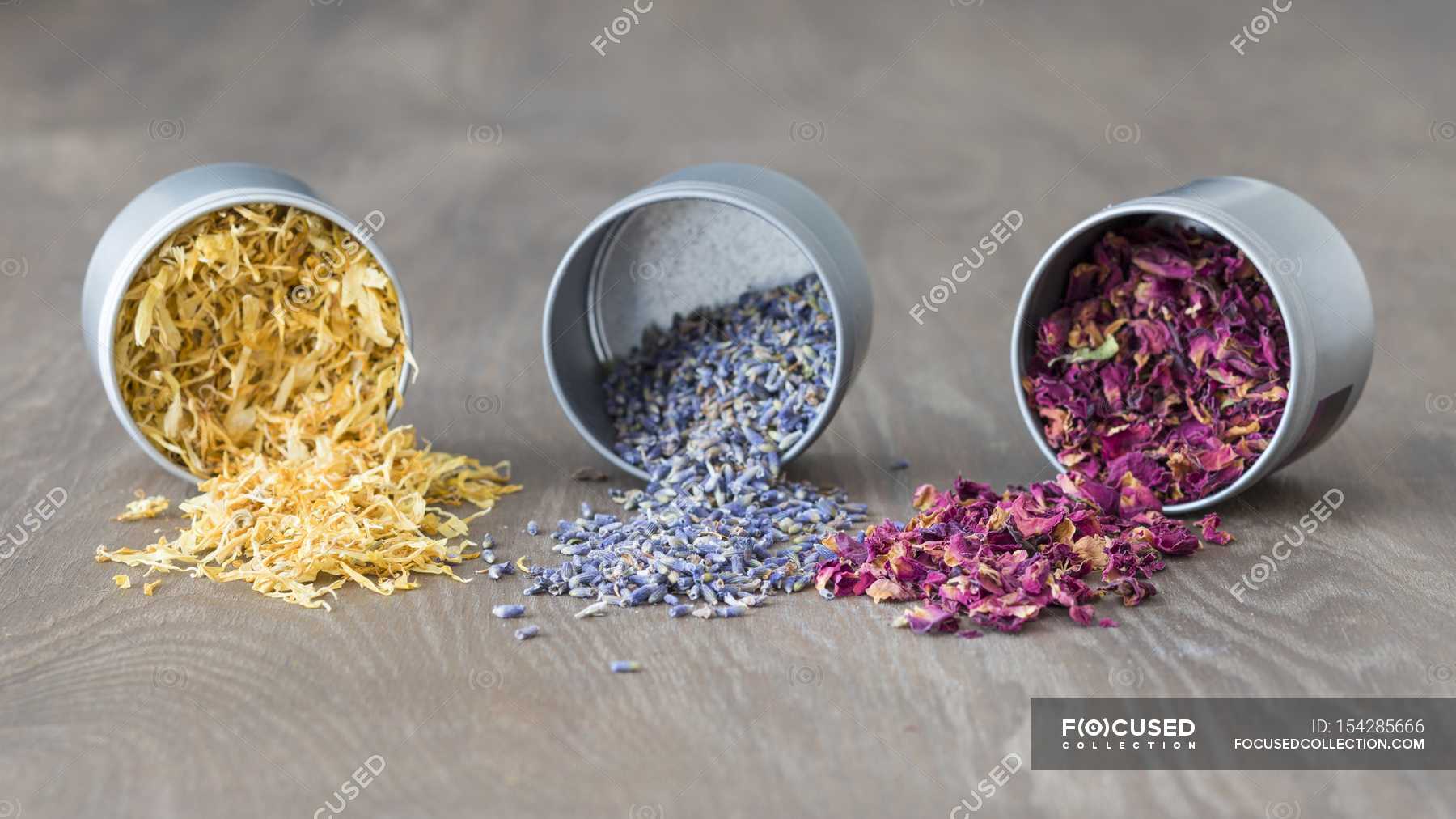 Dried marigold, lavender and rose petals in upturned tins — calories