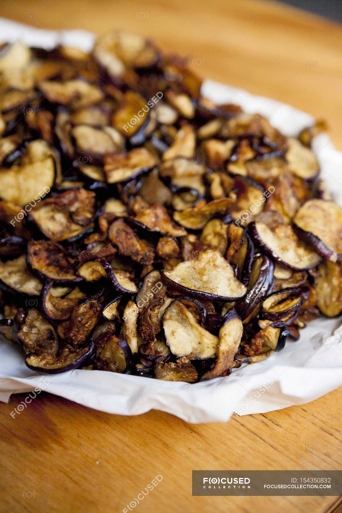 Pile of aubergine chips on paper — cookery, diet Stock Photo 154350832