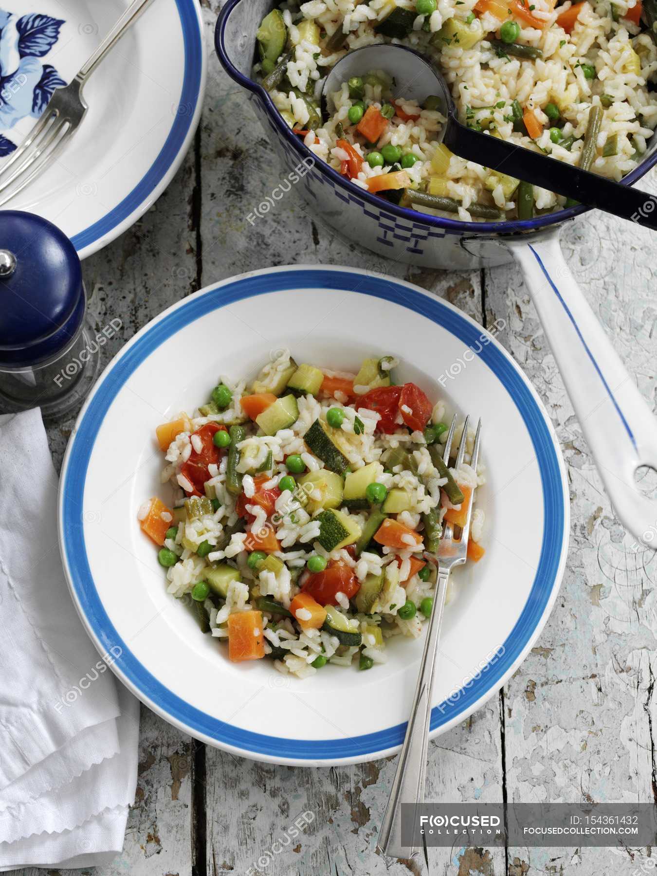 Mixed vegetable risotto on white and blue plate with fork — Ready To