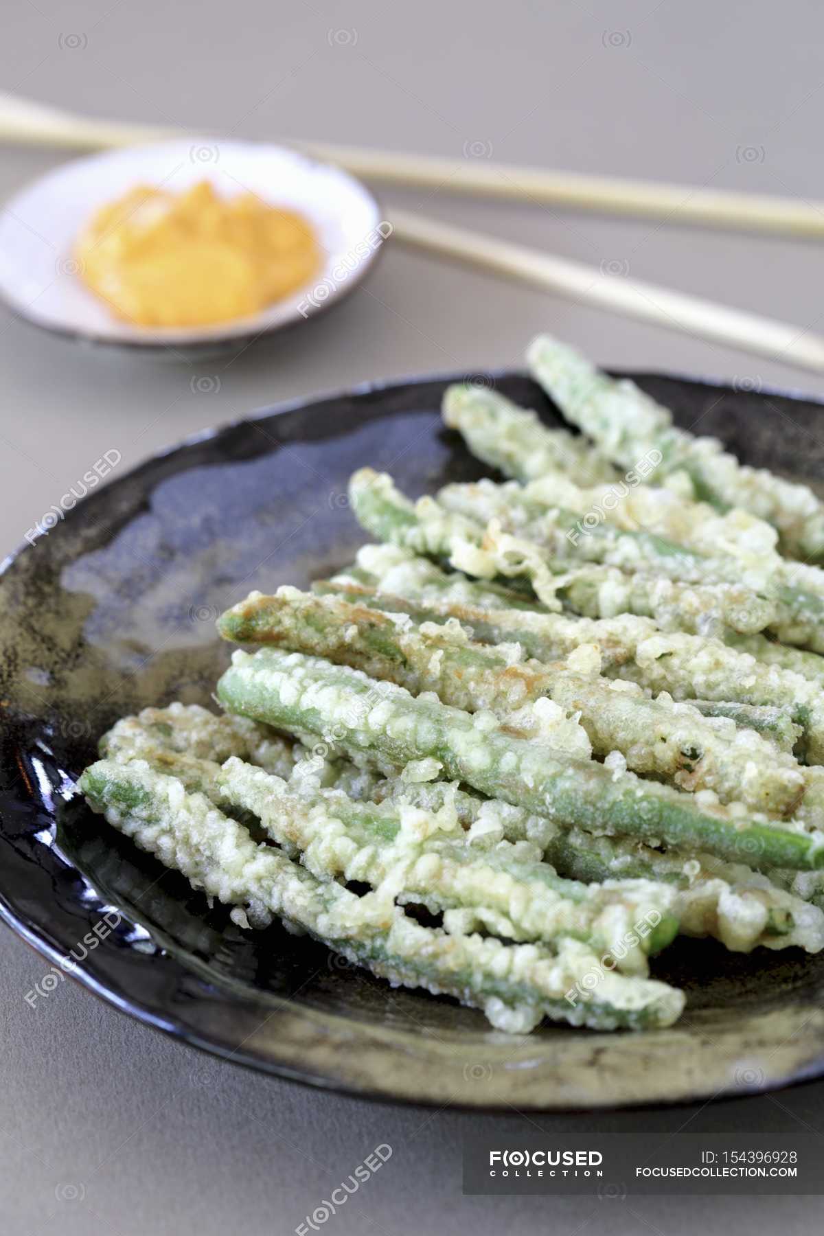 Green beans in tempura batter on black plate — gourmet, greenery