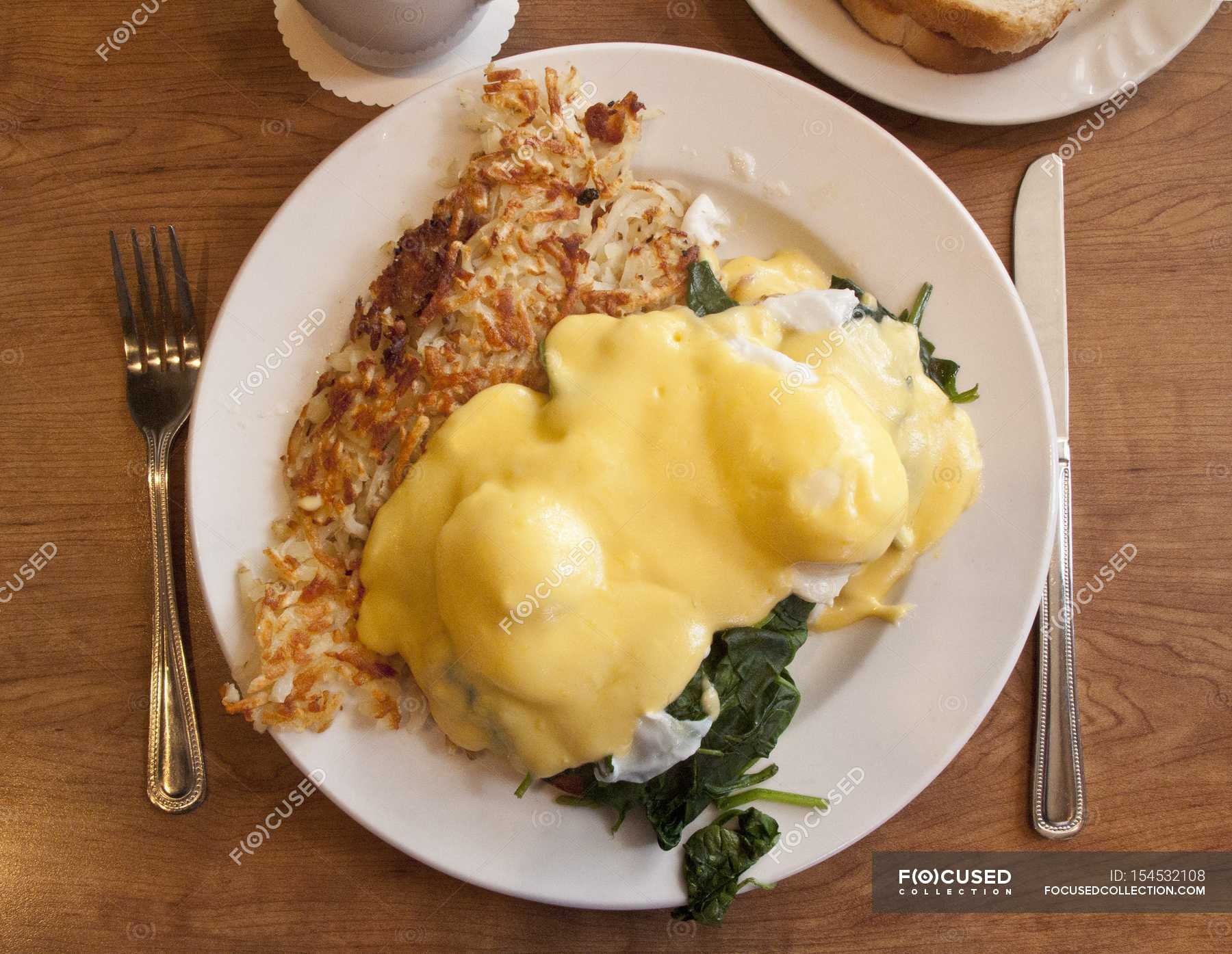 Eggs Benedict with spinach and omelette — appetizing, cutlery Stock