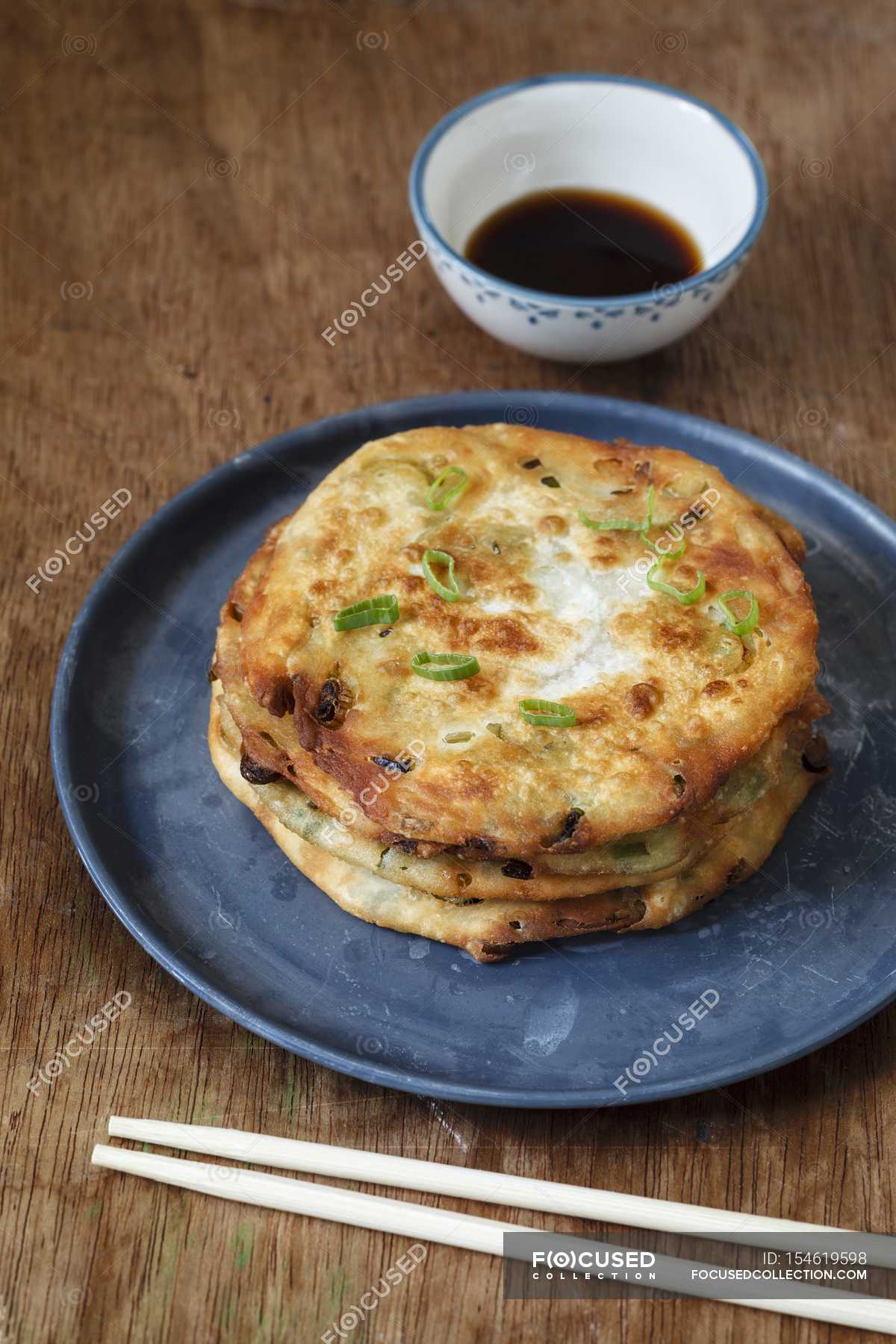 Cong You Bing fried spring onion fritters with a soya dip over wooden ...