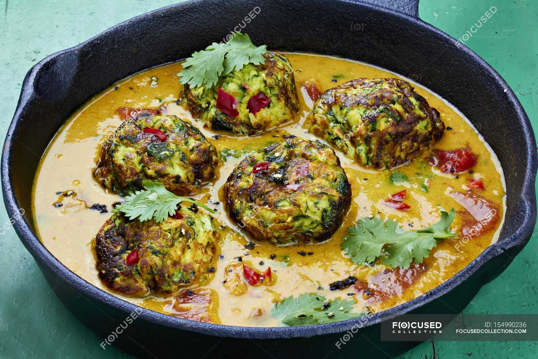 Courgette dumplings in a pepper sauce with coriander in black dish