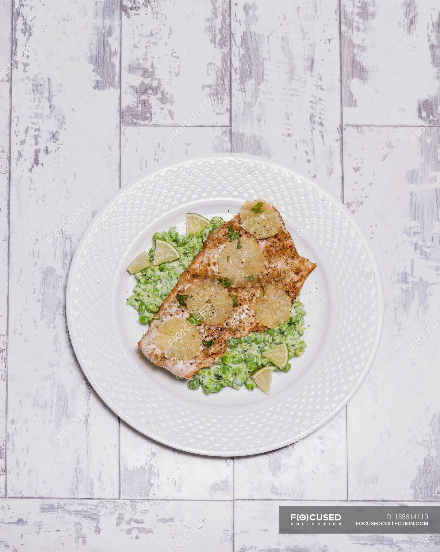 Trout With Lime And Coriander On Mushy Peas On White Plate Over Wooden Surface Meal Greenery Stock Photo 155514110