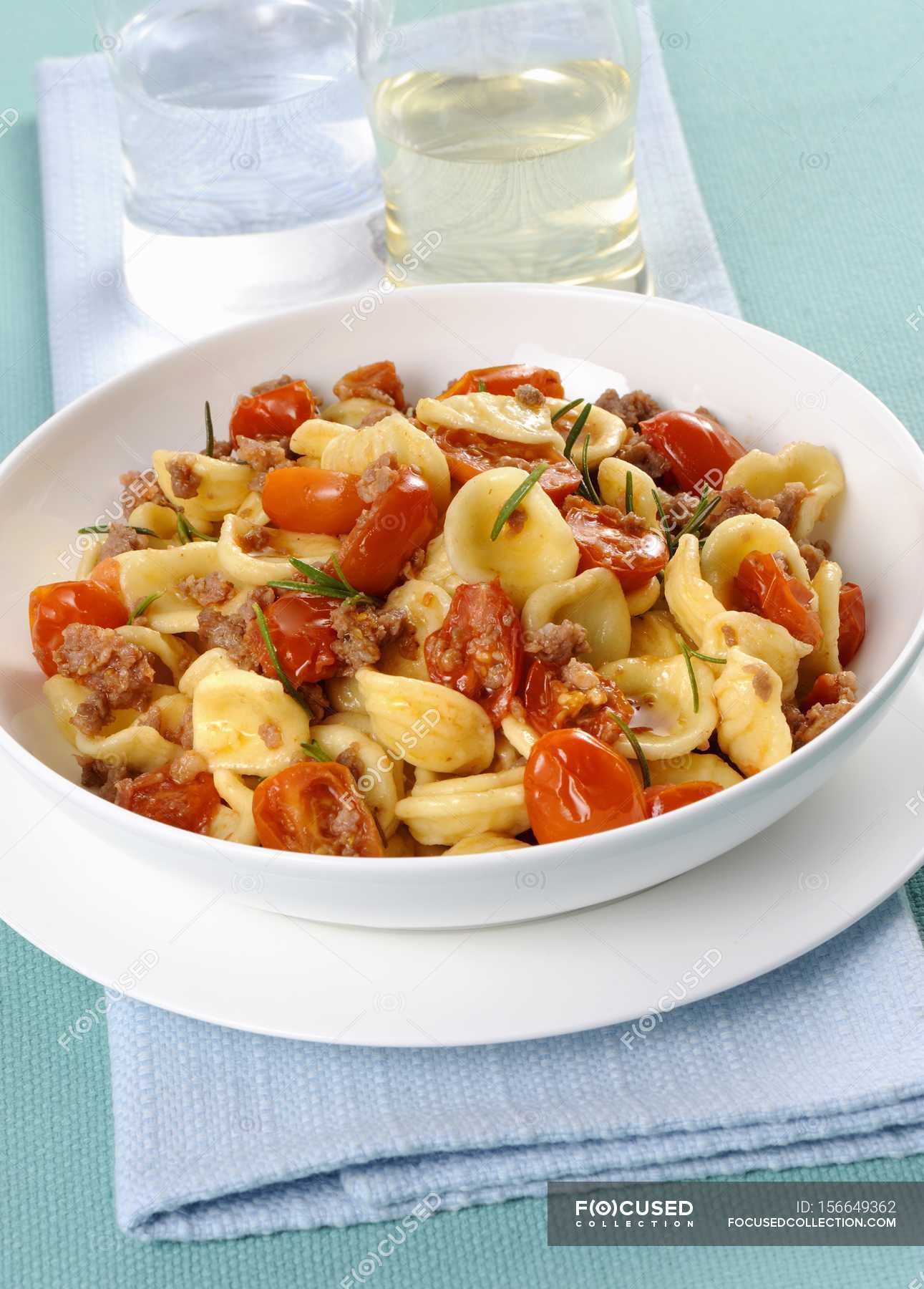 Orecchiette pasta with salsiccia sauce and tomatoes — healthy, staple food  - Stock Photo | #156649362