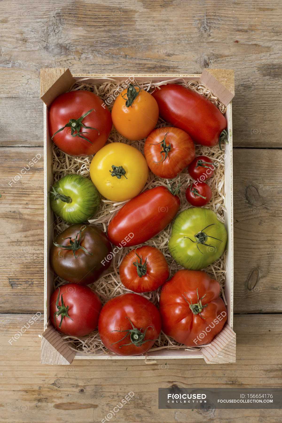 Crate of colourful tomatoes — backdrop, organic - Stock Photo | #156654176