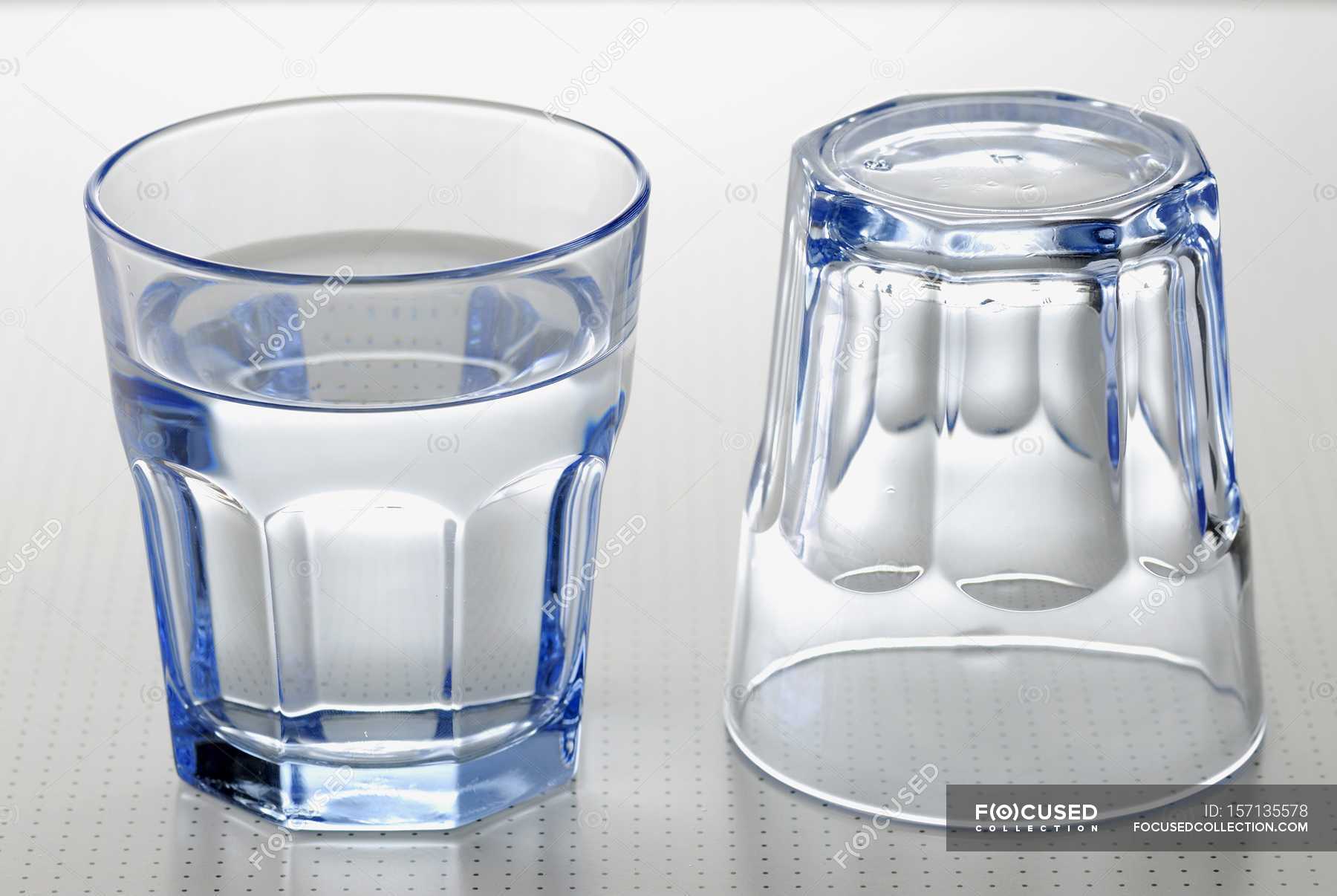 На столе стоят три склянки с водой. Чистый стакан. Стакан Pure. Стаканы для воды стеклянные серые. Пустой стакан.