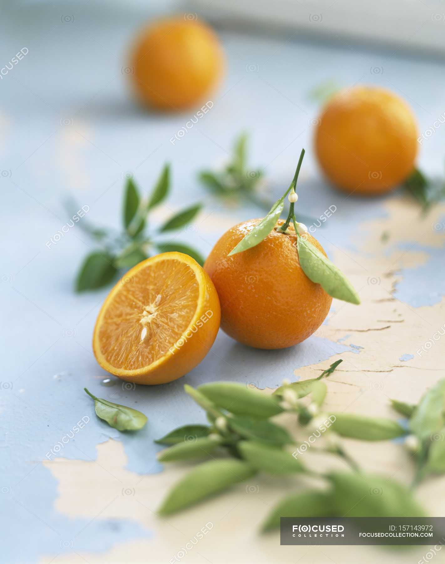 Fresh whole and halved Oranges — edible, rustic Stock Photo 157143972