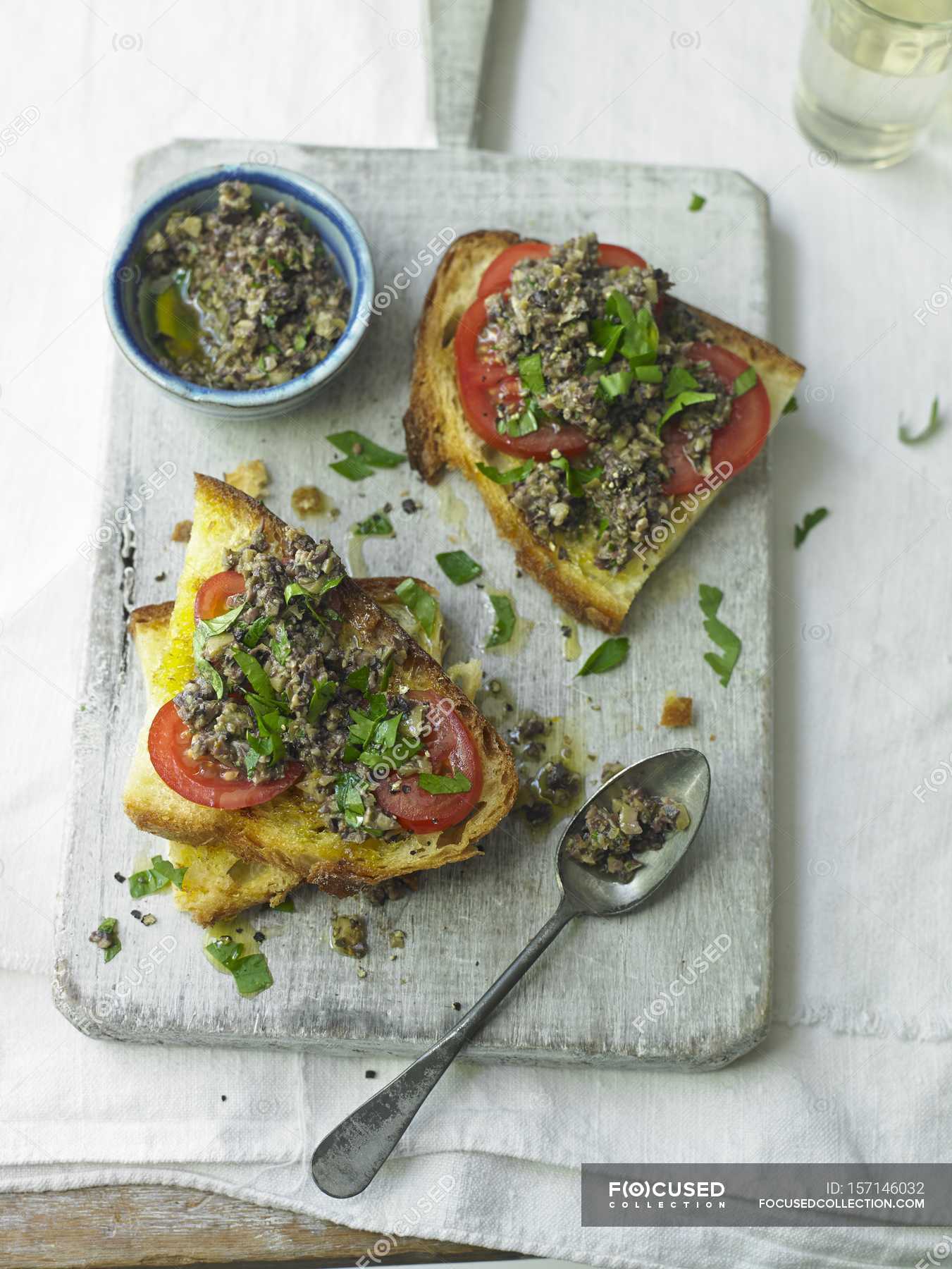 Tapenade on Toast over green desk on table — grain, traditional Stock