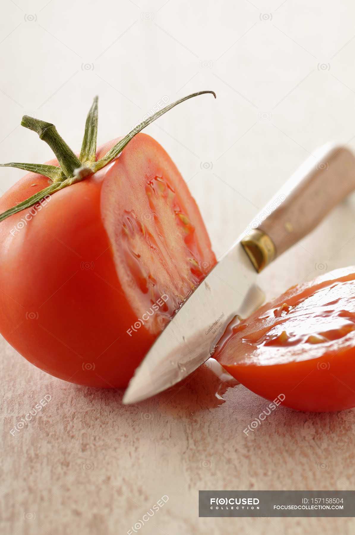 Cutting tomato with knife — background, recipe Stock Photo 157158504
