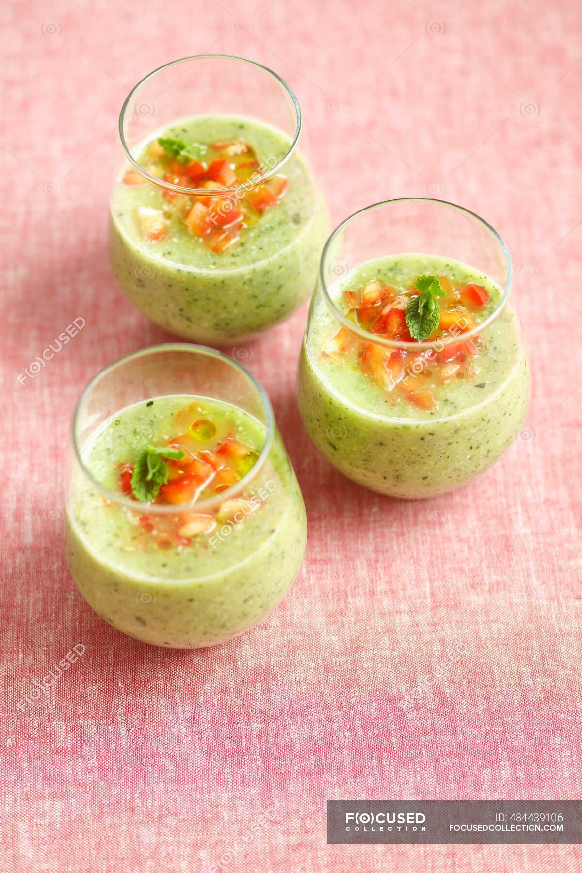 Cold courgette and mint soup garnished with diced red pepper and olive