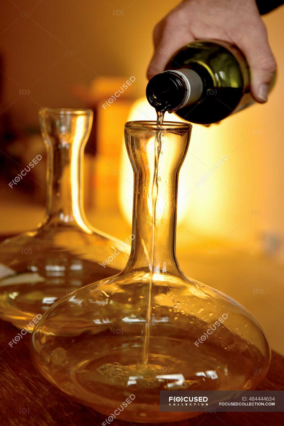 a white wine in a karaf — being decanted, human - Stock | #484444634