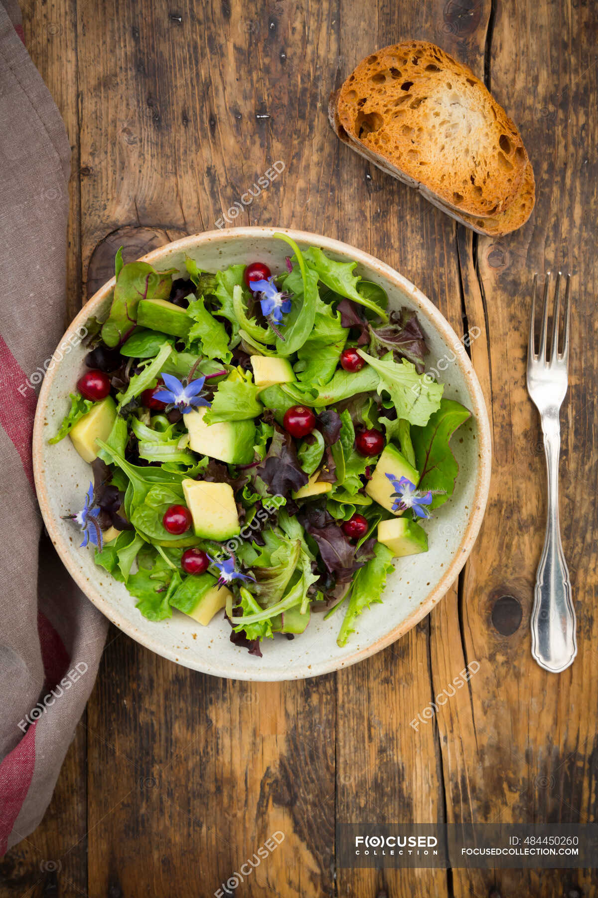 Mixed green salad with avocado, redcurrants and borage flowers