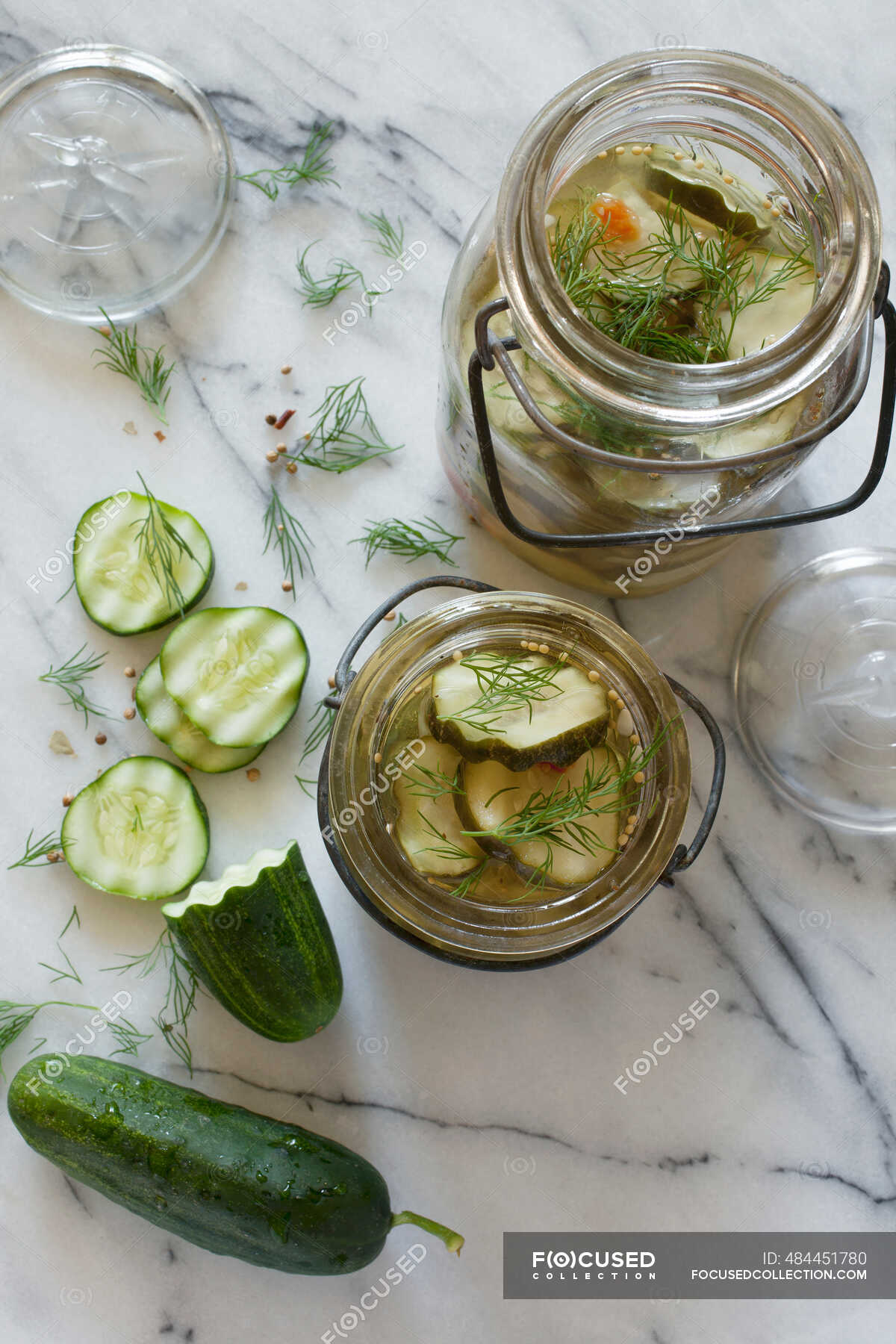 Whole and Sliced Pickling Cucumbers Marinating in Vintage Glass Jars