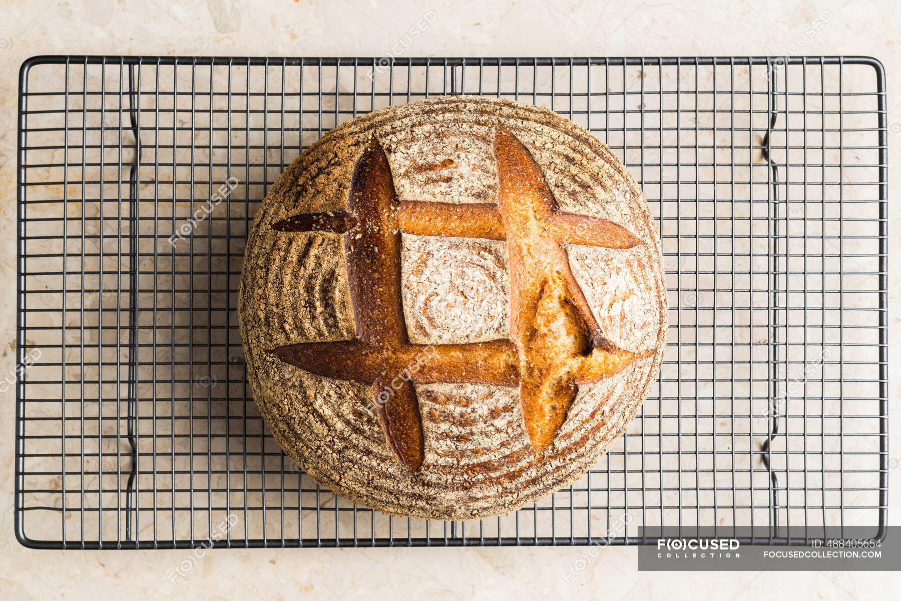 Mixed grain bread on a cooling rack — baking, one loaf Stock Photo