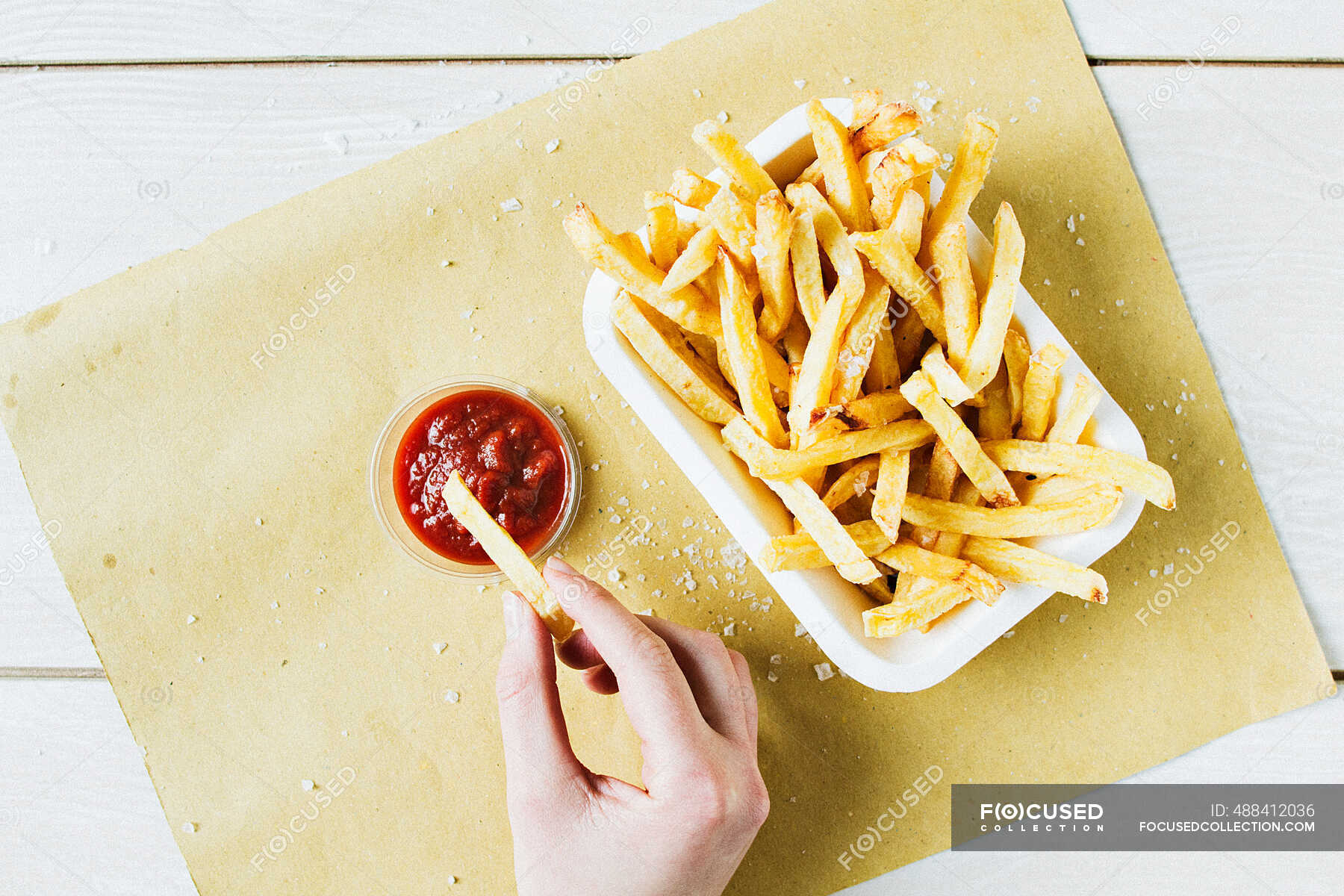 A Portion Of Chips With Sea Salt With A Hand Dipping One Into Ketchup — Catsup French Fries 9917