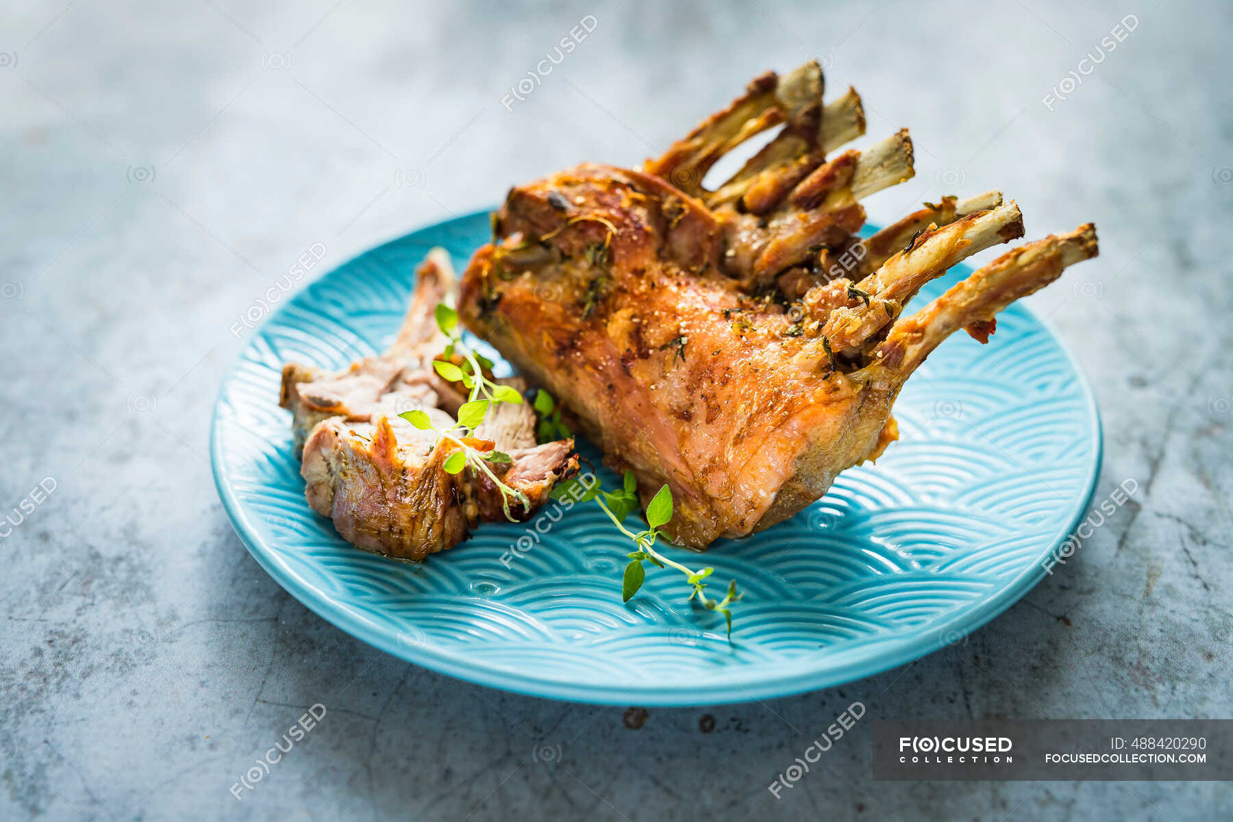 Simple roast veal with bones on a blue plate — selective focus, cooking technique Stock Photo