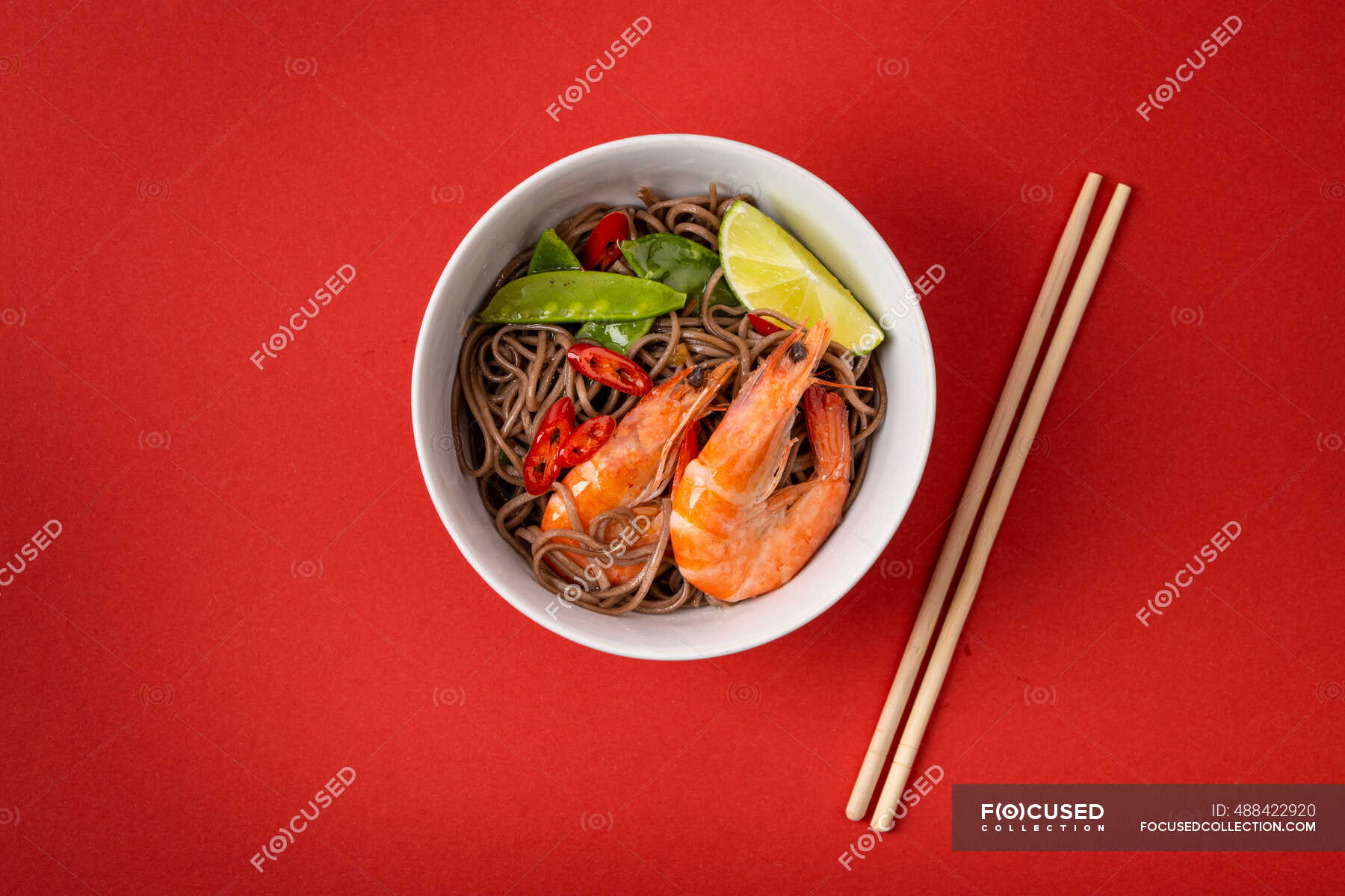 Asian stir fry soba noodles with shrimps, vegetables, green peas, red