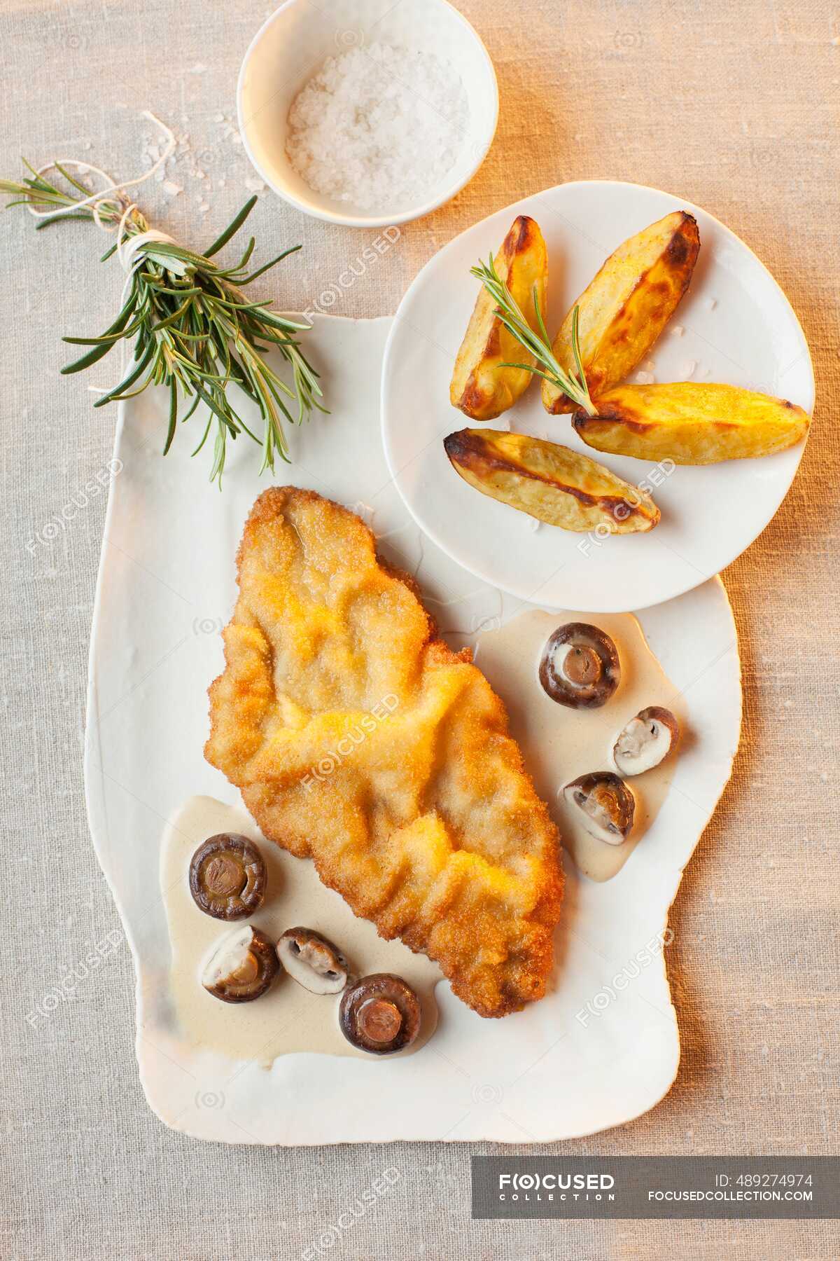Schnitzel in white wine and mushroom sauce with potato wedges — sauces