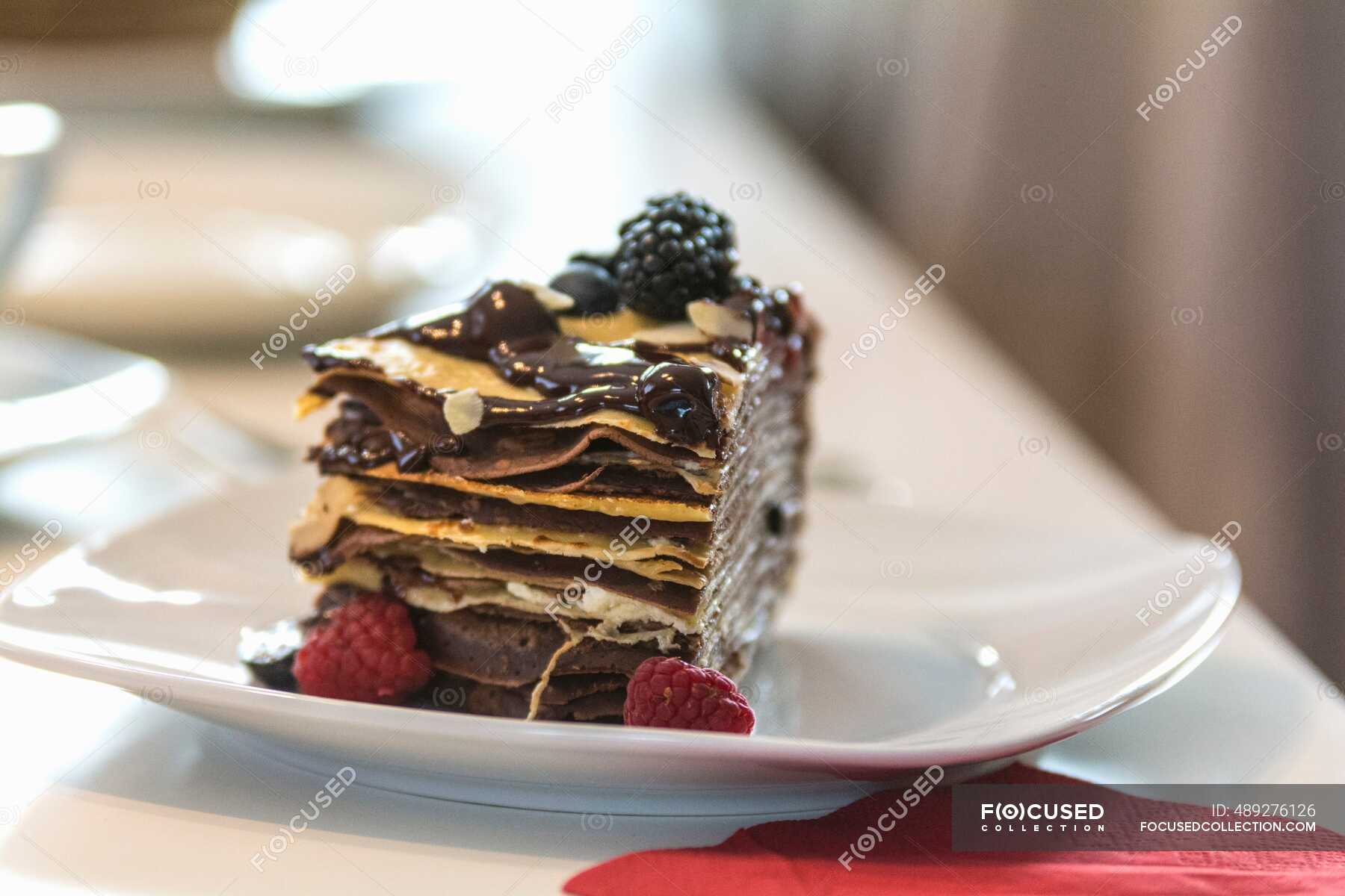A slice of pancake cake with berries and chocolate sauce — Sweet Food, patisserien Stock Photo