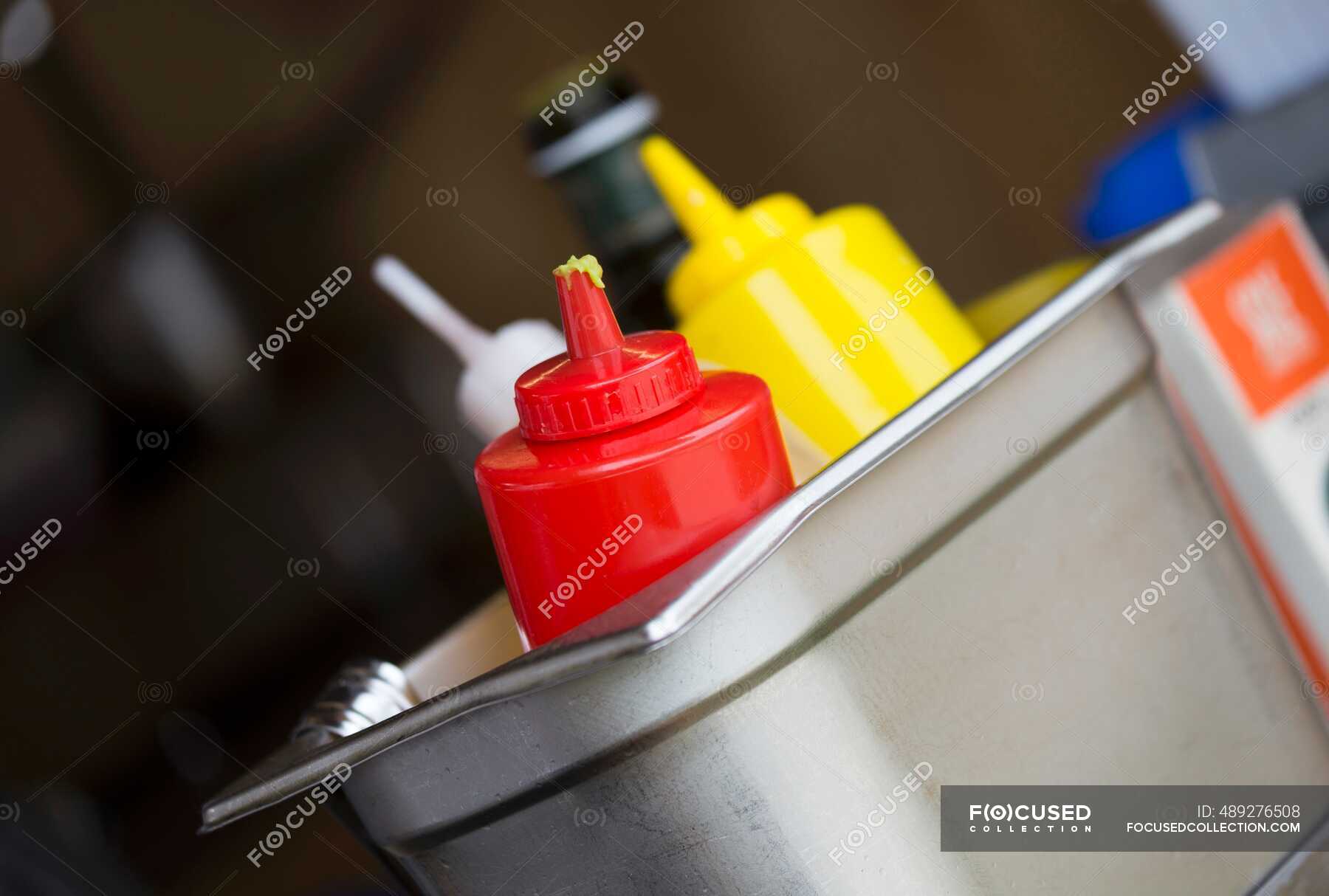 Ketchup, mustard and seasoning sauces in a metal container in a