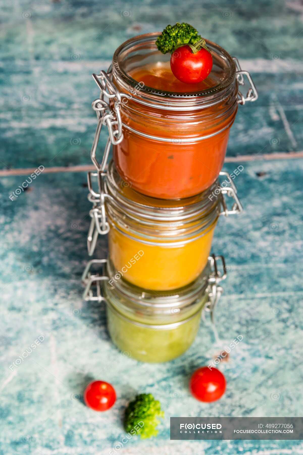 Various colorful soups in glass jars, broccoli soup, tomato soup
