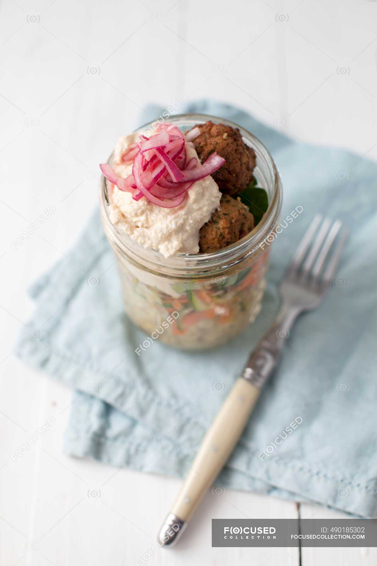 Vegan couscous salad with falafel, carrots, zucchini, houmous and red