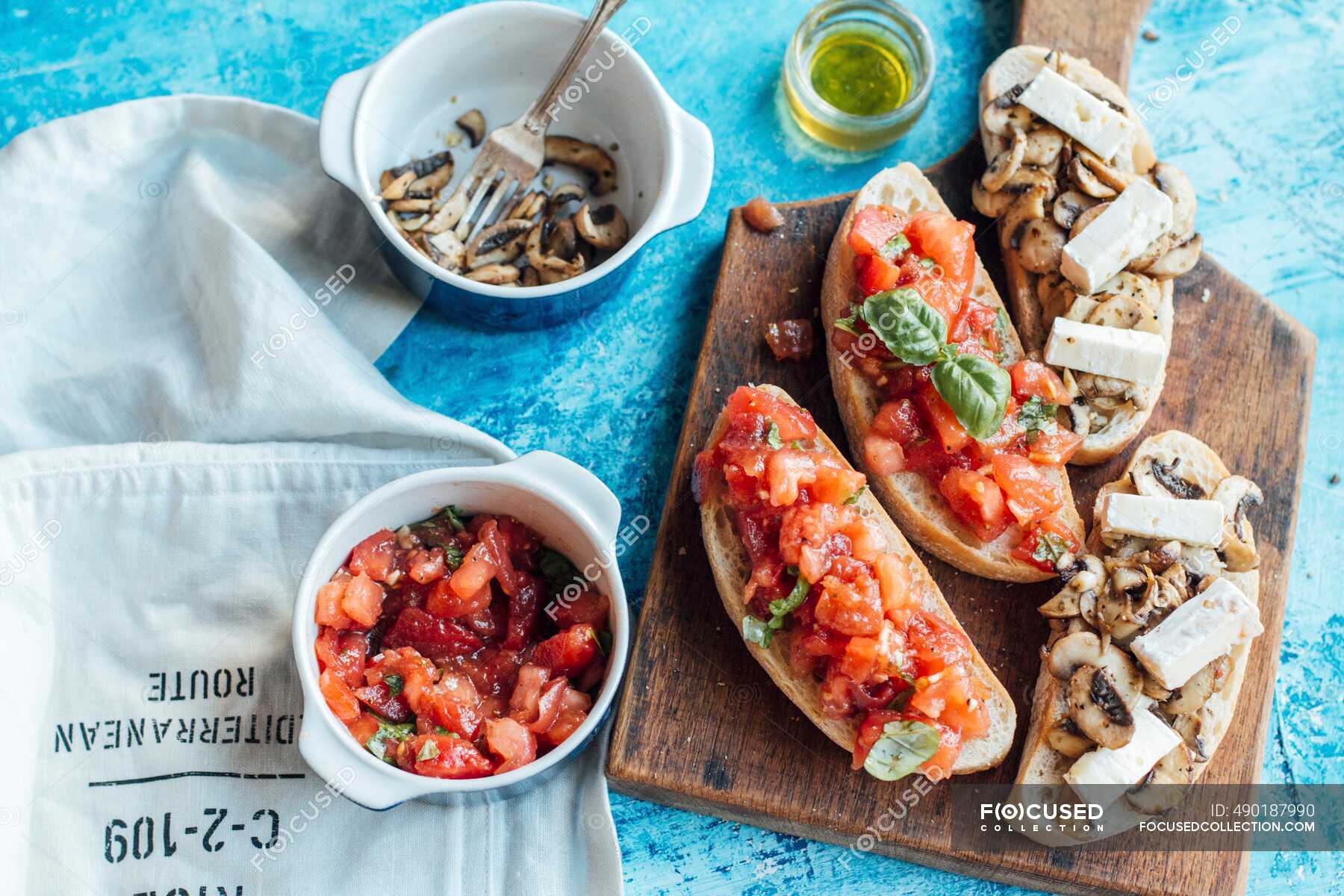 White chiabatta bread cut with toppings, tomato and mushrooms with brie ...