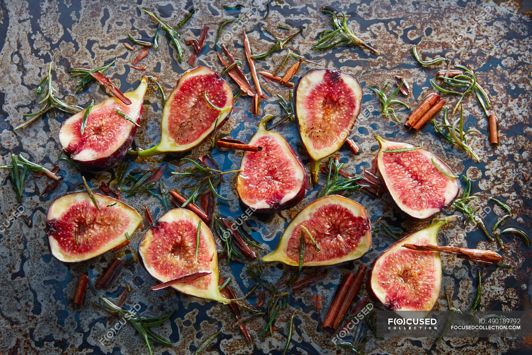 Roasted figs with honey, rosemary and cinnamon sticks on baking tray