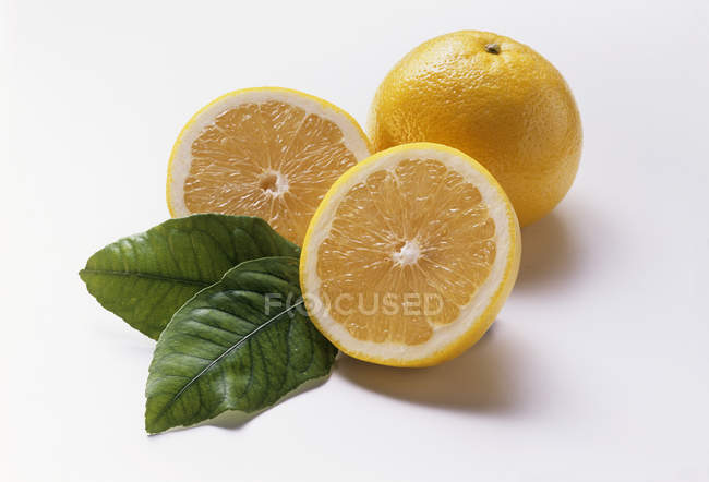 Grapefruit with halves and leaves — Stock Photo