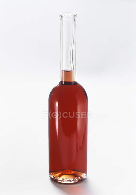 Primo piano vista di aceto in una bottiglia di vetro su sfondo bianco — Foto stock