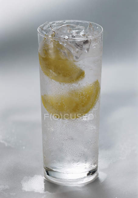 Primo piano vista di acqua con spicchi di limone — Foto stock