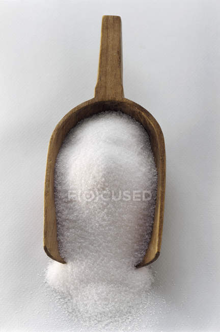 Açúcar em uma colher de madeira — Fotografia de Stock