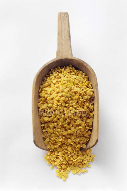 Split Yellow Peas on wooden scoop on white background — Stock Photo