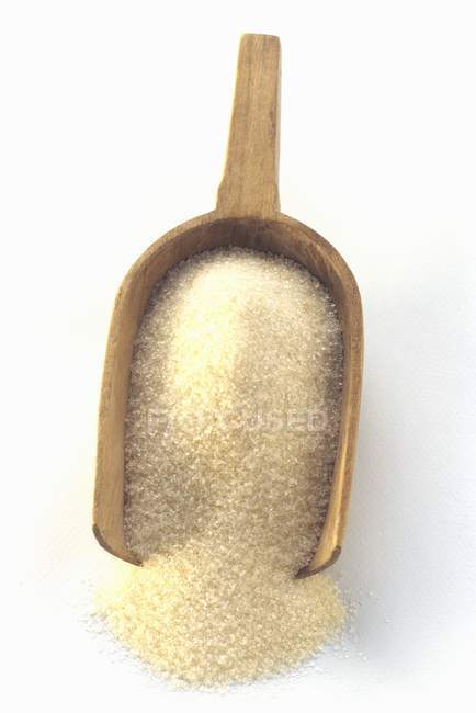 Azúcar en una cucharada de madera - foto de stock